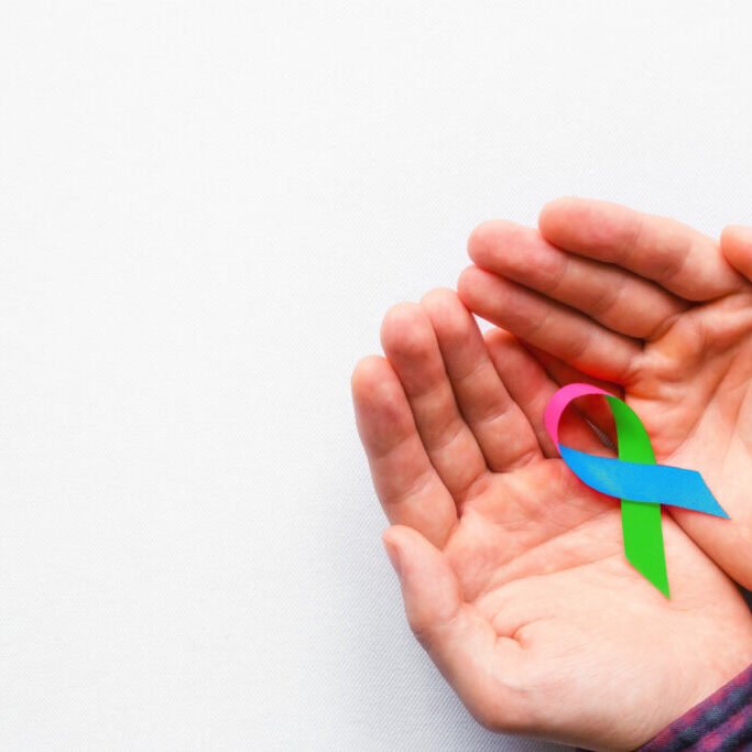 man holding a symbol of World AIDS Day